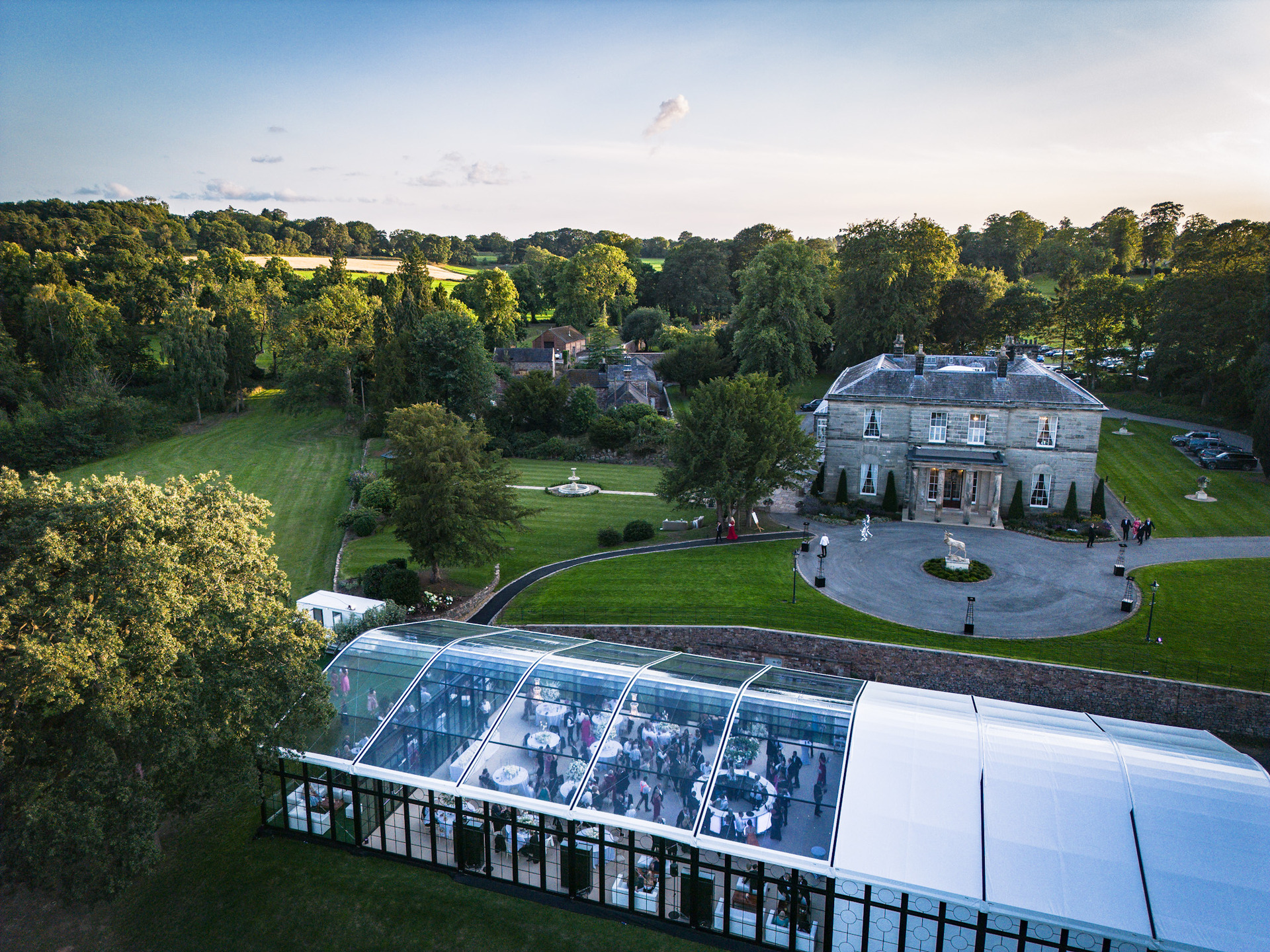 Aerial view of a glass marquee beside a country house