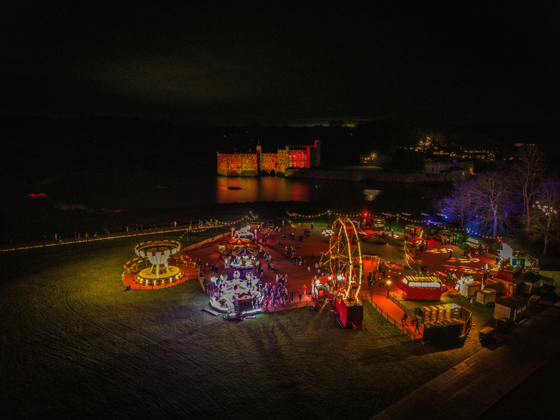Aerial night view of the Christmas fair and light trail in front of Leeds Castle