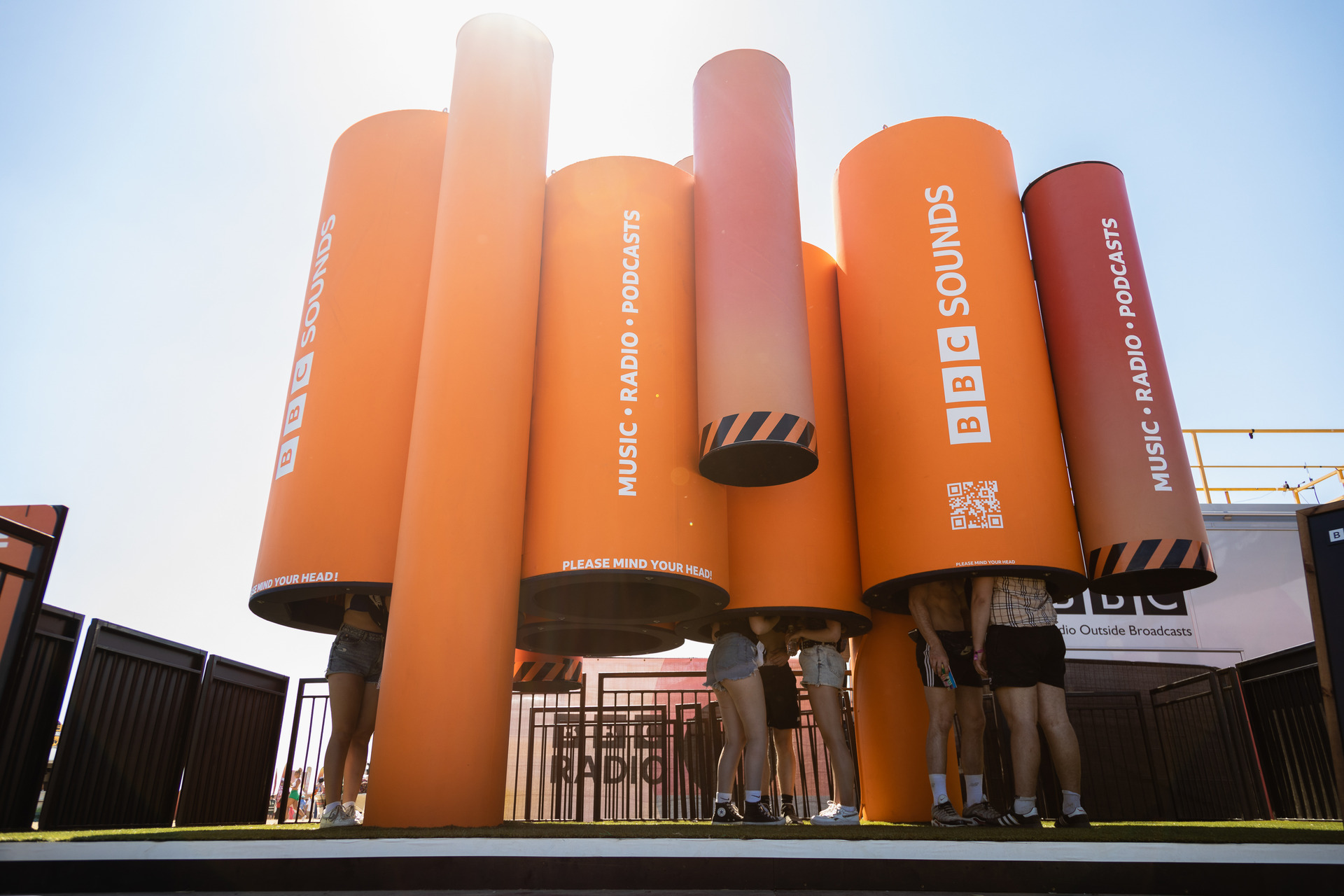 Orange listening-pod installation at a festival